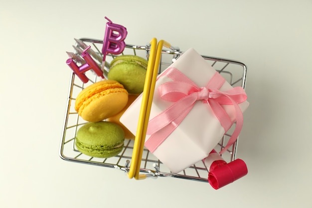 Shop basket with birthday accessories on white background