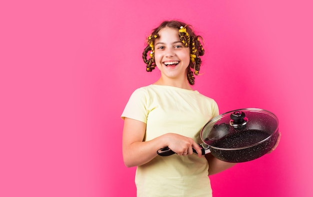 Acquista utensili per la casa accessori per la cucina servizi culinari e domestici stereotipo stile casalinga bambina con i bigodini nei capelli ragazza stretta padella ragazzino tieni la padella per cucinare pasto pin up style