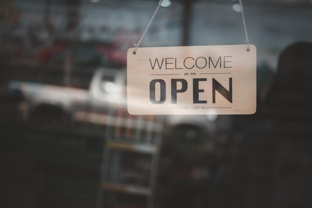 Insegna di apertura negozio presso la porta a vetri in toni vintage