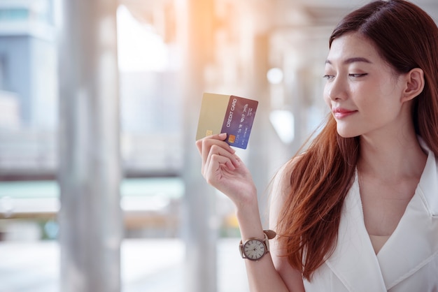 Shopaholic Woman holding shopping bags ,money ,credit card at shopping malls