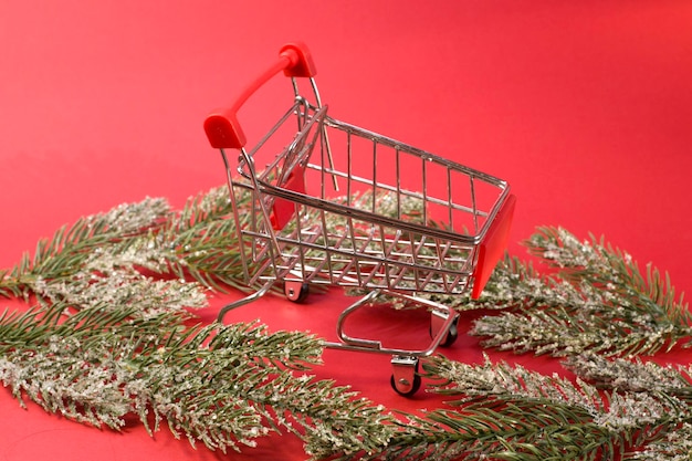 Shoping cart with fir branches basket supermarket winter holiday sales seasonal sales black friday