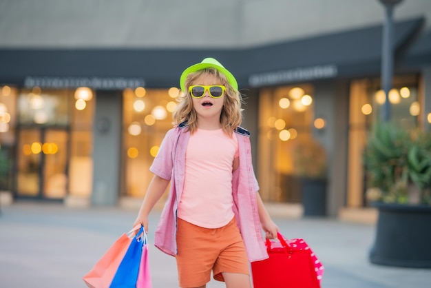 Shopper fashion child on shopping portrait of a kid with shopping bags fashion child in shirt sungla