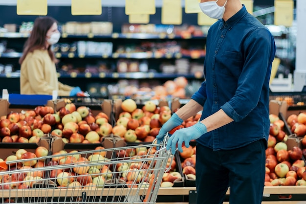 Shoppers in beschermende maskers staan op veilige afstand in een supermarkt