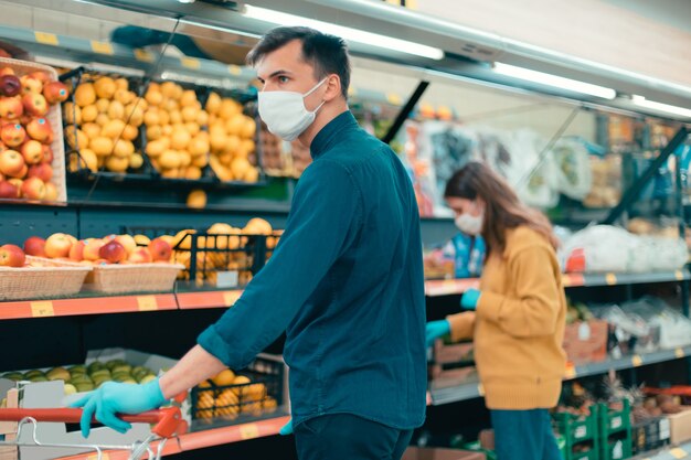 Shoppers in protective masks choosing fruit in the supermarket . coronavirus in the city