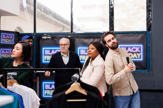 Shoppers snuffelen tussen kleding op Black Friday, mensen die op zoek zijn naar koopjes. Werknemers van kledingwinkels organiseren jaarlijks een detailhandelsevenement en verwelkomen klanten in een moderne modewinkel