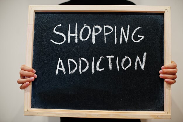 Shopping addiction written on chalkboard