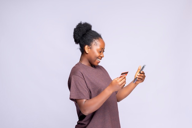 Shopping App sideview of Excited Black Woman Using Mobile Phone And Credit Card Purchasing Online