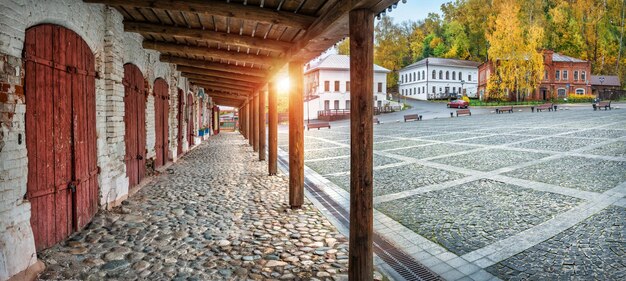 Торговые ряды с деревянными ставнями на мощеной площади осенним Плесом