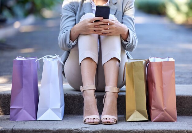 Shopping bag city and woman on smartphone for e commerce customer sale and online discount with zoom of shoes or feet Retail cellphone and urban street of customer with online shopping app luxury