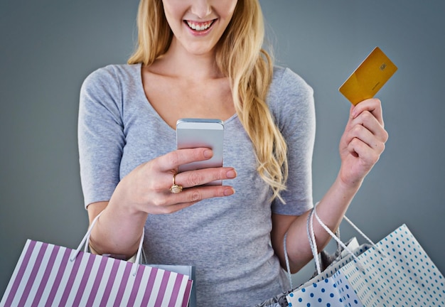 shopping bag credit card and phone with hands of woman in studio for black friday deal gift and discount savings promotion and boutique product with person on gray background for vip customer