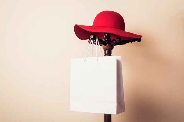 Photo shopping bag and red hat hanging on wooden hanger