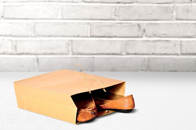 Photo shopping bag with brown flat shoes on the table