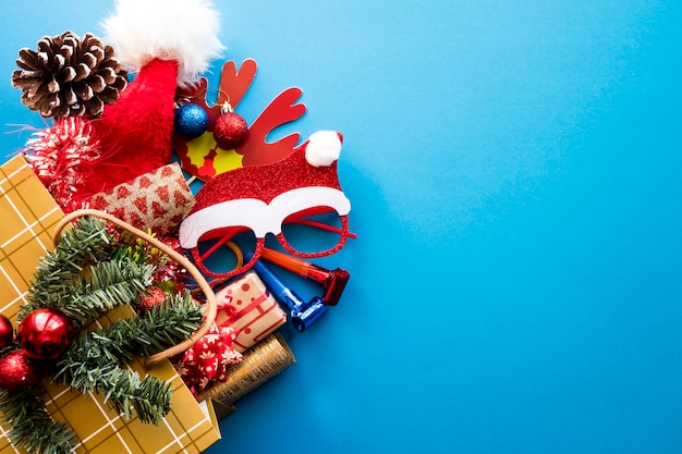 파란색 배경에 크리스마스 선물과 장식품이 있는 쇼핑백. 복사 공간