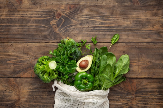 나무 테이블에 녹색 야채와 함께 쇼핑 가방 건강 식품 구매
