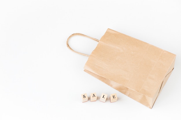 a shopping bag and the word sale made of wooden letters