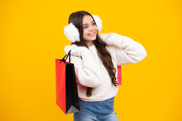 Shopping bags in the kids hands Teen girl after shopping Purchases black friday discounts and sale concept Autumn shopping sale