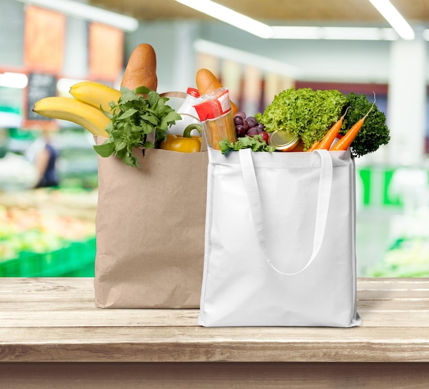 Shopping bags with vegetables and fruits on the table