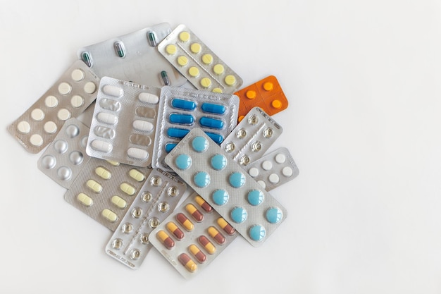 Shopping basket cart full of pills and medical supplies over light grey background