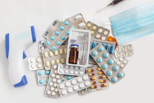 Shopping basket cart full of pills and medical supplies over light grey background