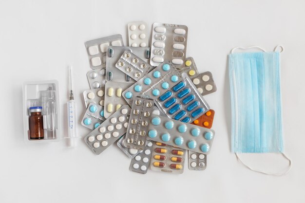 Shopping basket cart full of pills and medical supplies over light grey background