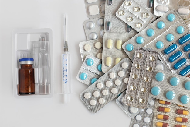 Shopping basket cart full of pills and medical supplies over light grey background