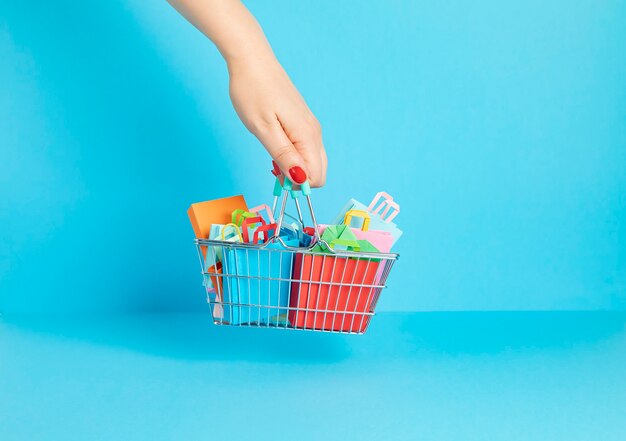 Shopping basket full of paper bags. Seasonalsale, online deals, discounts, promotion, shopping addiction concept