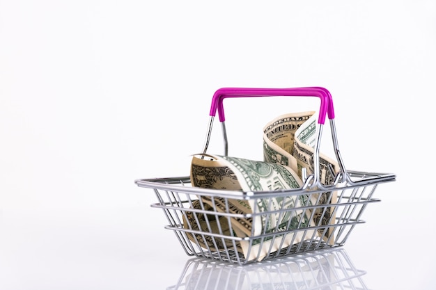 Shopping basket and US dollars on a white background. Copy space.