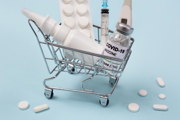 파란색 배경 코로나바이러스에 covid19의 의약품과 백신이 있는 쇼핑 바구니