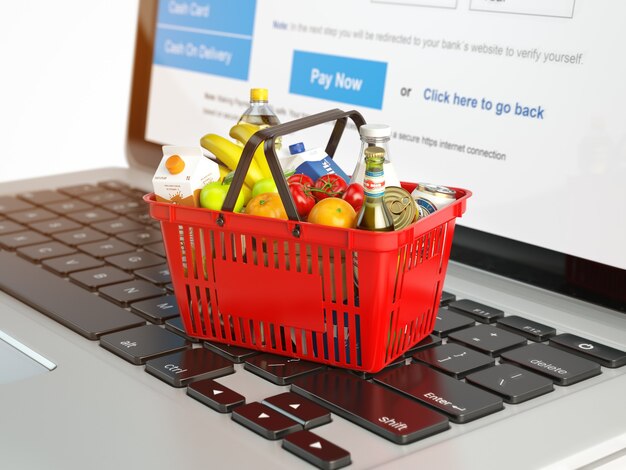 Shopping basket with variety of grocery products on laptop keyboard