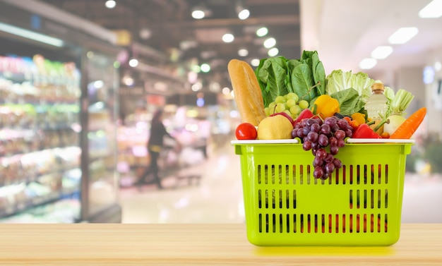shopping basket on wood table with supermarket background