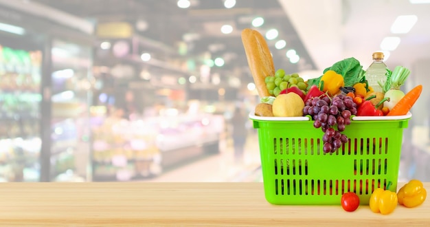 Shopping basket on wood table with supermarket grocery store blurred defocused background