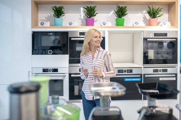 Photo shopping. blonde pretty customer choosing goods in a showroom