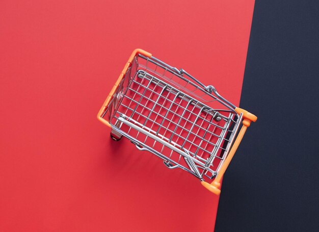 Shopping cart on black and red background blue