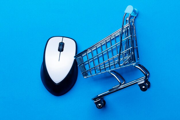 Shopping cart on a blue background with computer mouse