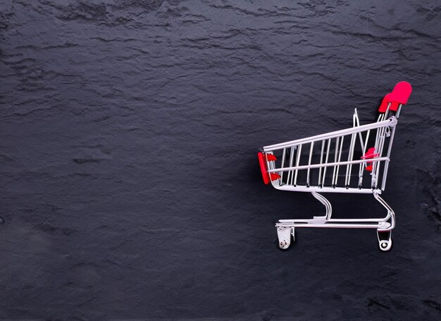 shopping cart on dark background with copy space