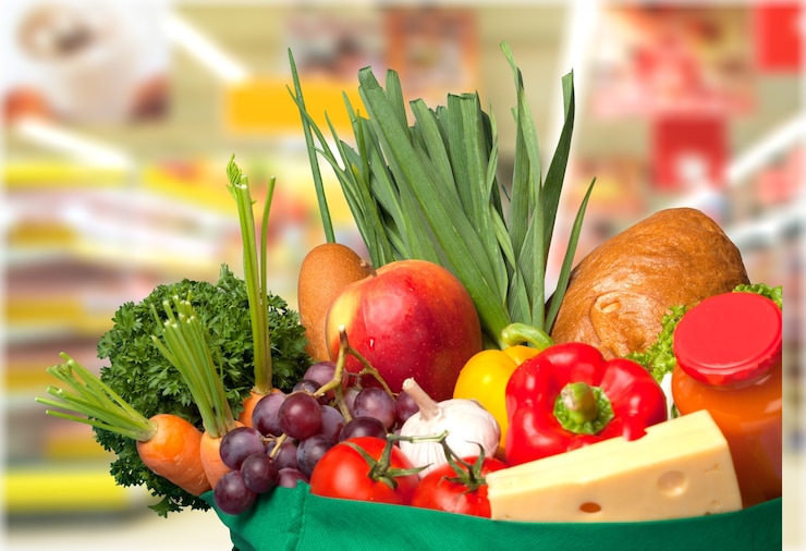 Фотография коляска для покупок, наполненная различными продуктами в магазине
