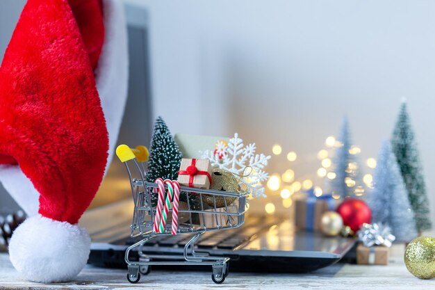 Shopping cart full of gift boxes and Christmas tree on keyboard of laptop computer Concept online shopping and holiday sale