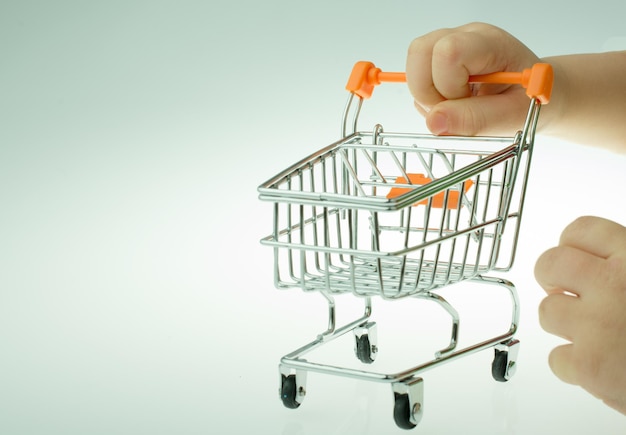 Photo shopping cart in the hand on white background