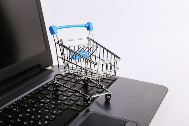 Shopping cart is on the laptop. Online sales concept.