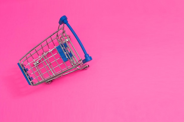 Shopping cart isolated on pink background