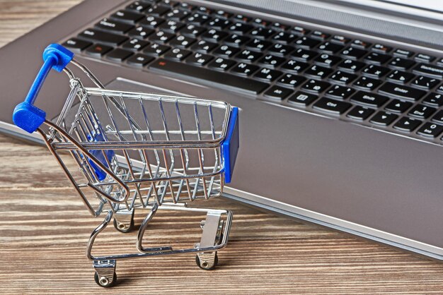 Shopping cart and laptop on table