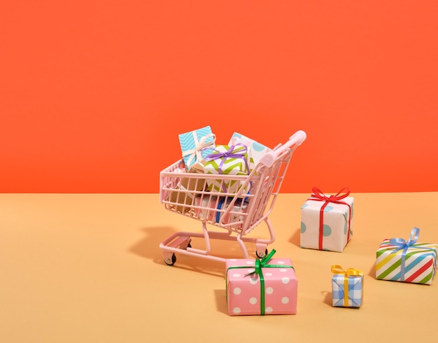 A shopping cart and lots of festive brightly colored gifts Preparing for a birthday party Copy space for text