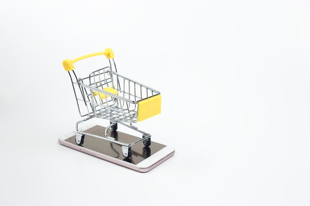 Shopping cart on smartphone white background. Shopping online supermarket on internet. business sale purchases digital marketing.