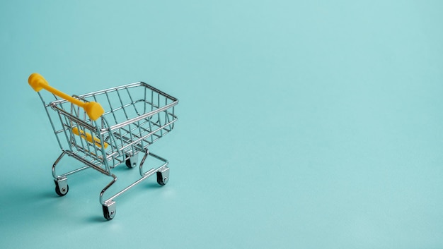 Shopping cart staggered on blue copy space