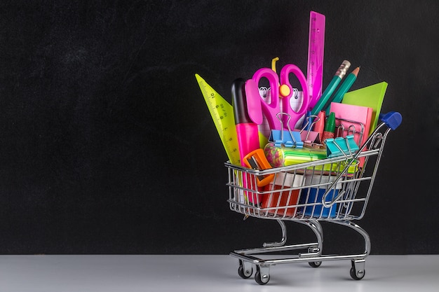 Shopping cart stocked with school supplies and a blackboard