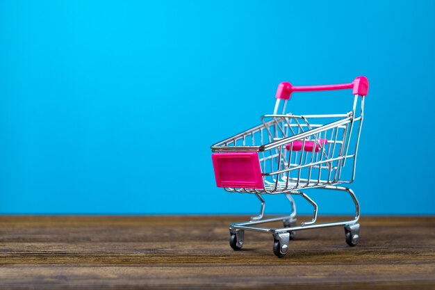 Shopping cart or supermarket trolley on wood