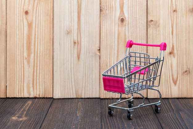 Shopping cart or supermarket trolley on wood