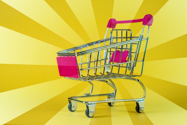 Shopping cart or supermarket trolley on yellow