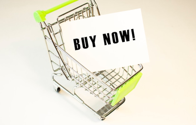 Shopping cart and text BUY NOW on white paper Shopping list concept