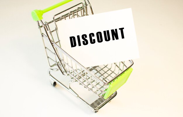 Shopping cart and text DISCOUNT on white paper